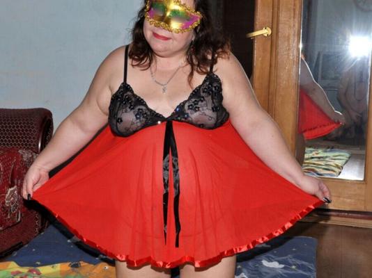 Meine BBW-Frau trägt ein rotes Kleid und eine Maske.