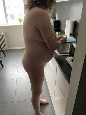 BBW con barriga redonda desnuda en la cocina