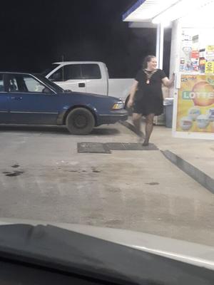 Esposa en el estacionamiento de una gasolinera rural para comentarios, sin límite